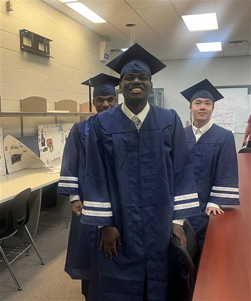  3 students with their cap and gowns 