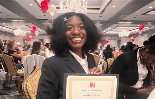  A student holding a certificate and smiling