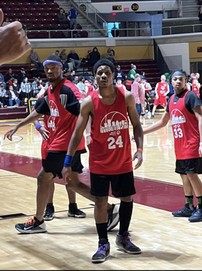 three students playing basketball