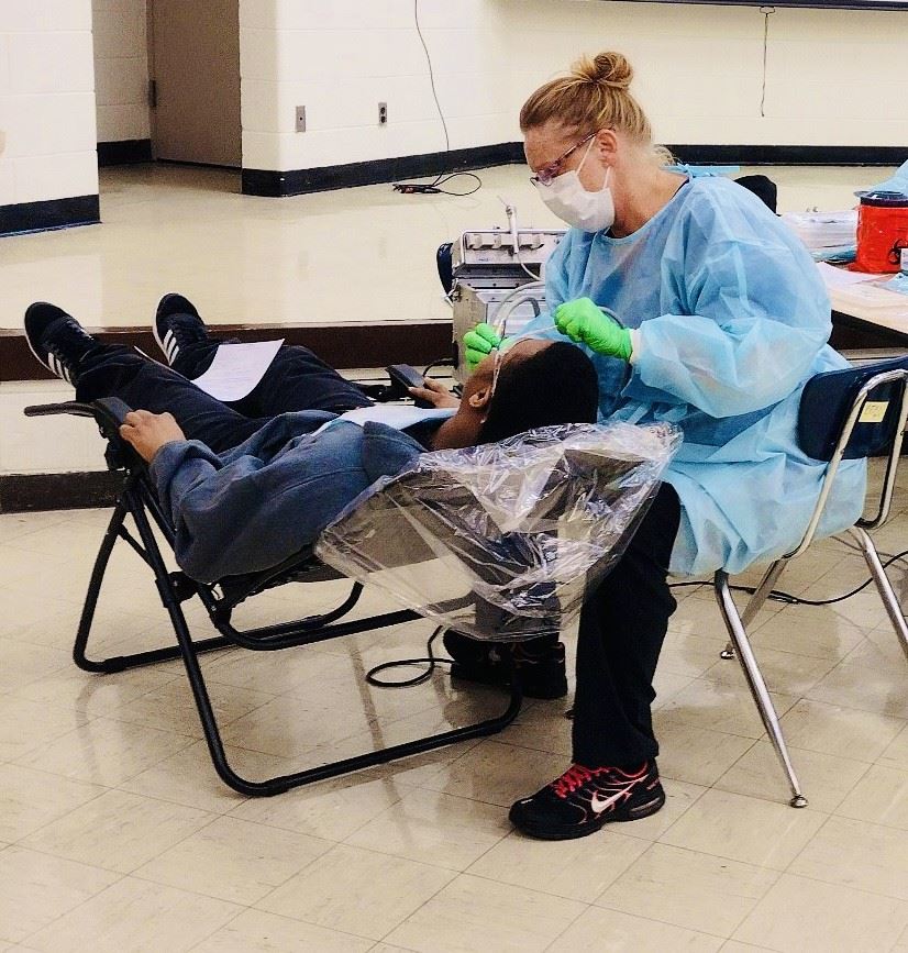  Dentist cleaning student teeth