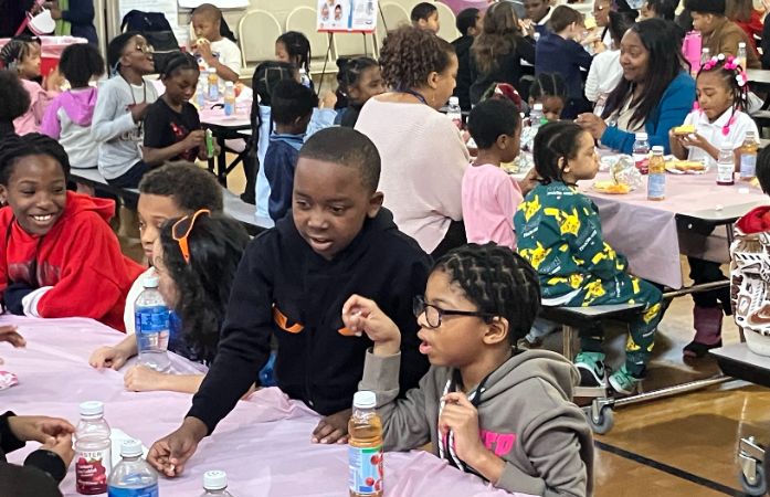  Two second graders talking as they eat their catered breakfast