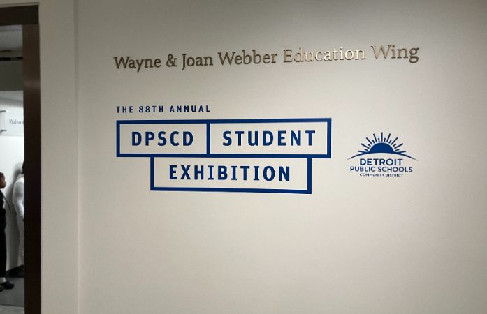 Entranceway to the exhibit with a large sign displaying the show's title
