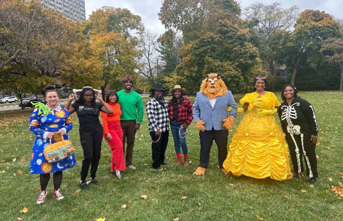 A group of the parent who contributed to the event, posing together, dressed in various costumes