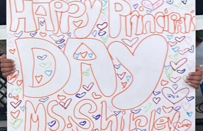 Student drawn poster showing many, colorful hearts, and "Happy Principal's Day Ms. Shirley" on it.
