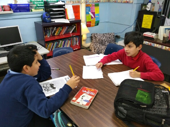 Two students discussing their classwork
