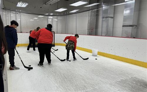 students shooting hockey pucks