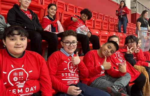 students smiling in matching red shirts