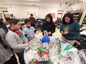 Ms. Solano and three students making pinatas 