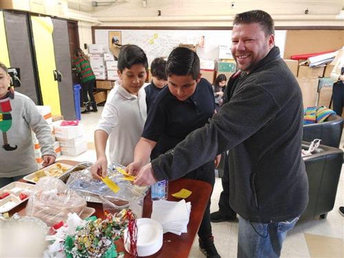 Mr.Lacey and 2 students casting their votes for best tamale 