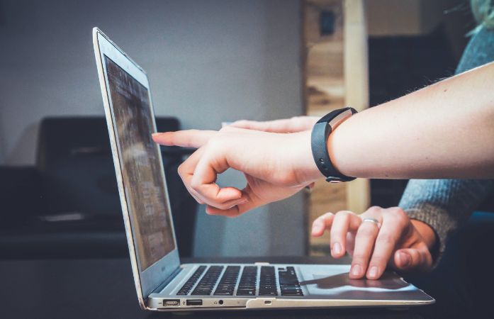  hands pointing to laptop