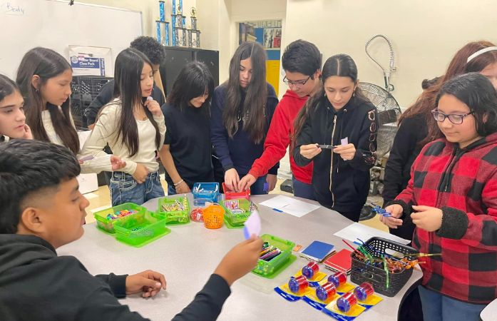  students looking at a table of prizes
