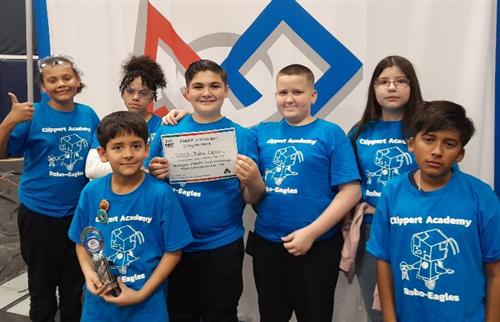 robotics team standing with trophy