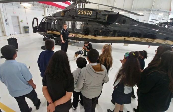  students standing in front of a helicopter