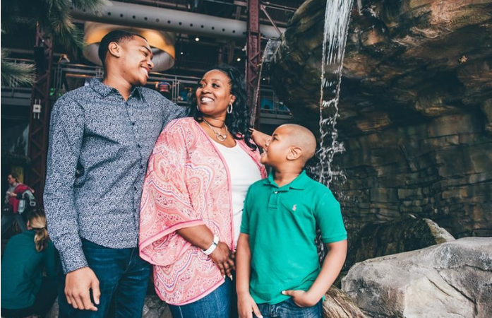  Parents and child in front of waterfall at science center