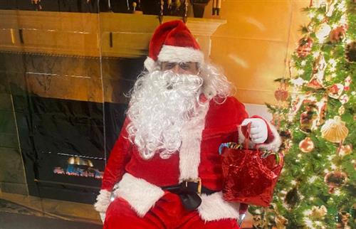 Picture of Santa Clause in front of a fire and Christmas tree