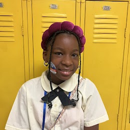 5th grade student smiling at camera with I voted sticker on her cheek