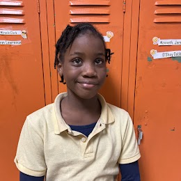 student smiling in front of lockers