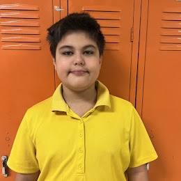 student smiling in front of lockers