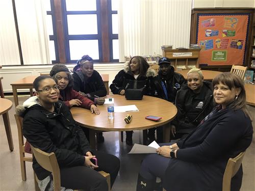 numerous people sitting around table smiling