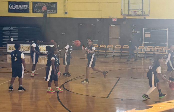 9 girls on the court playing baskeball