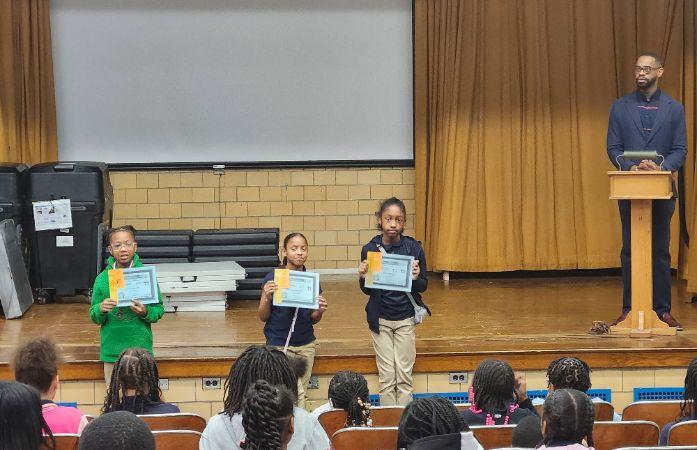 Fifth thought Six grade  scholars that  received a certificate standing in front of the stage.