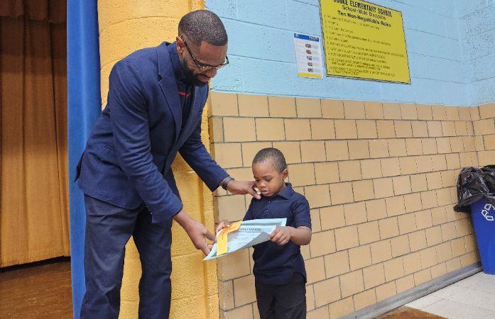  Principle Drain presenting a scholar his certificate for the month of October