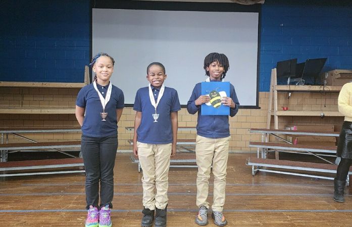  Three students standing on the stage.