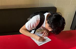 student filling out a voter registration application