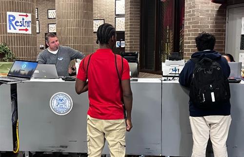 2 students waiting in line at the mobile unit counter