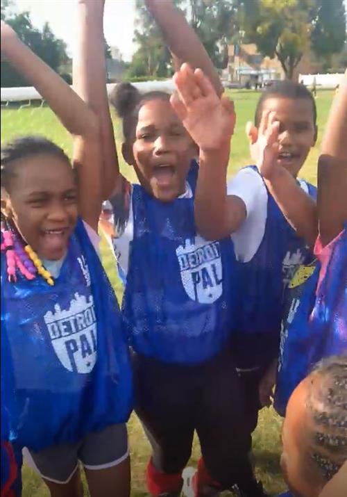 Children on a soccer team celebrating 