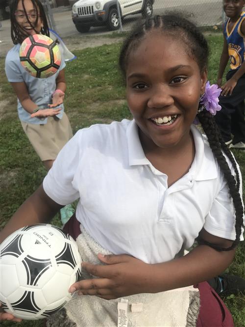smiling student holding soccer ball