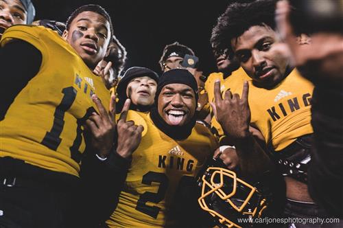 King football players in gold uniform