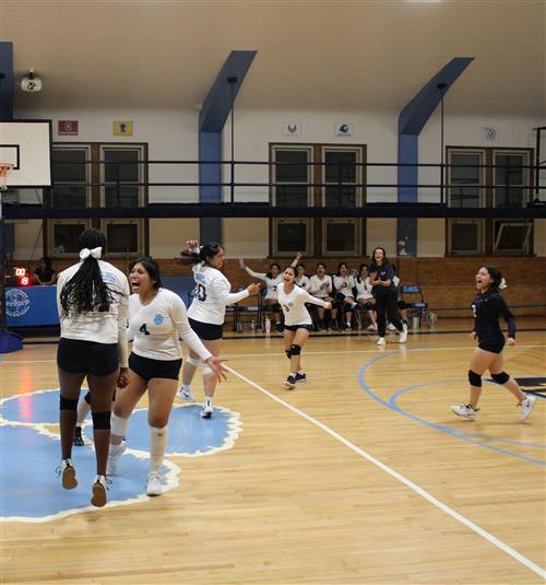 students celbrating at volleyball game