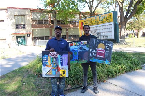 Program organizers hold student artwork