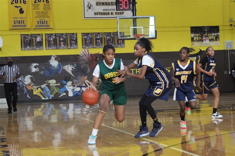  Dossin girls basketball players dribbles past opponent