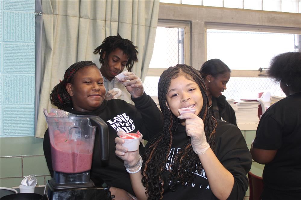  Students hold their smoothies up with big smiles