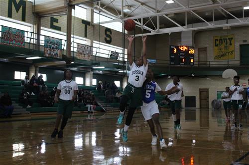 Basketball player shoots ball.