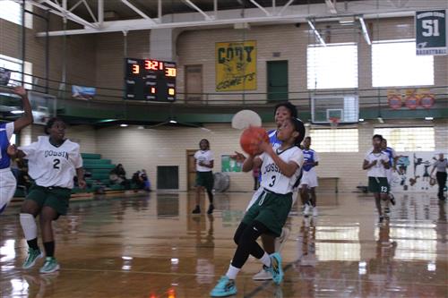 Basketball player shoots ball.