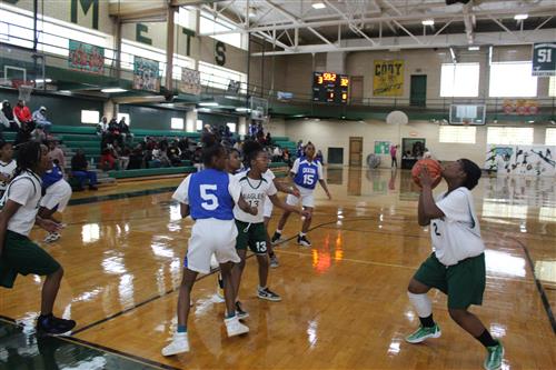Basketball player shoots ball.