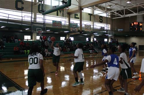 Basketball player shoots ball.
