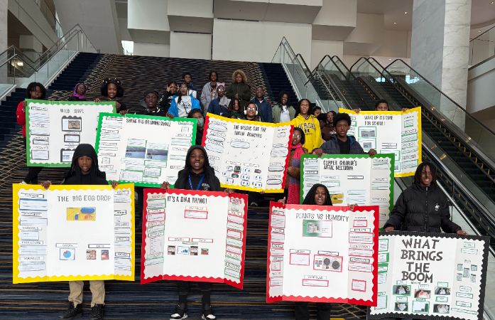  Students holding their Science Boards on the steps.