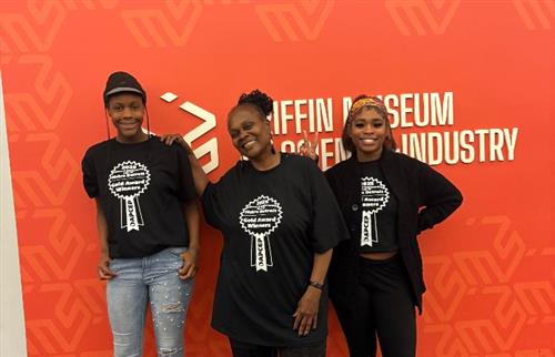 3 females wearing black t-shirts