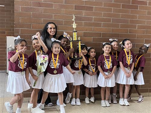  students smiling with trophy