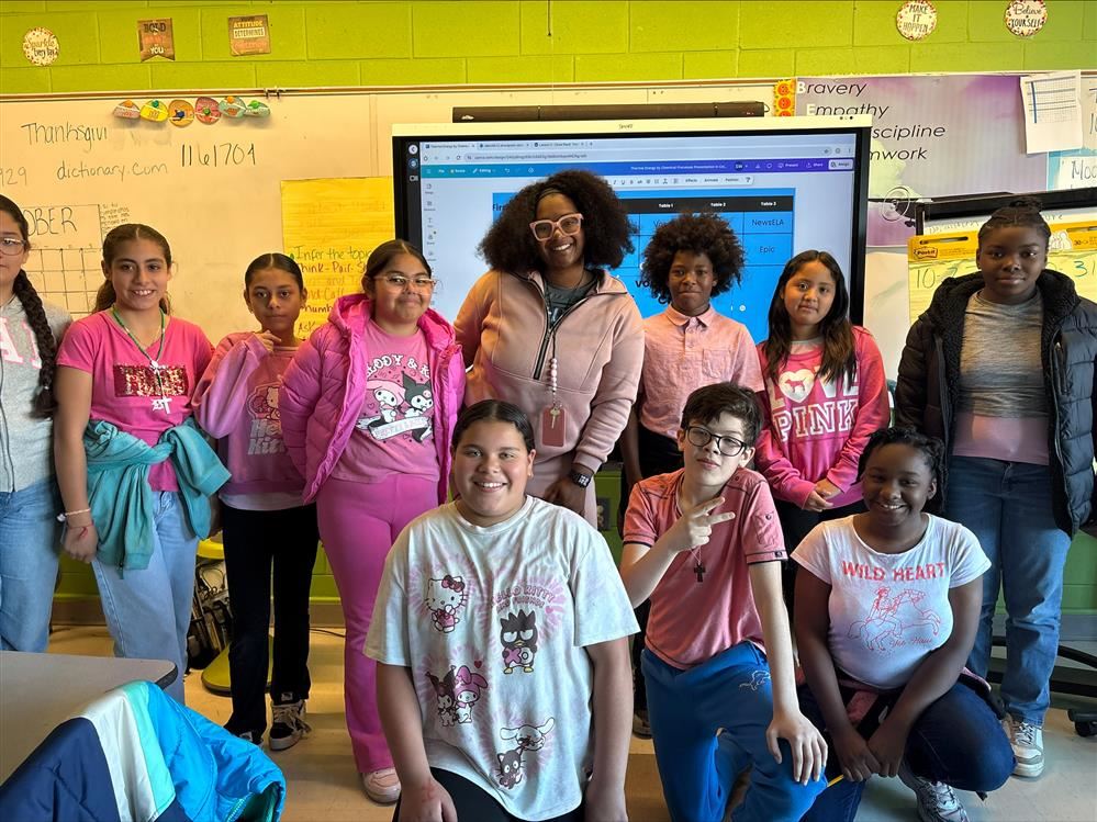 Students and teacher smiling in pink tshirts