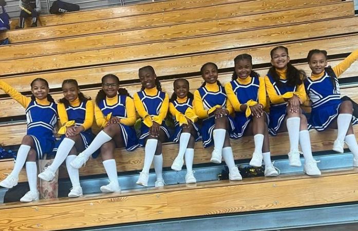  cheer team sitting on bleachers