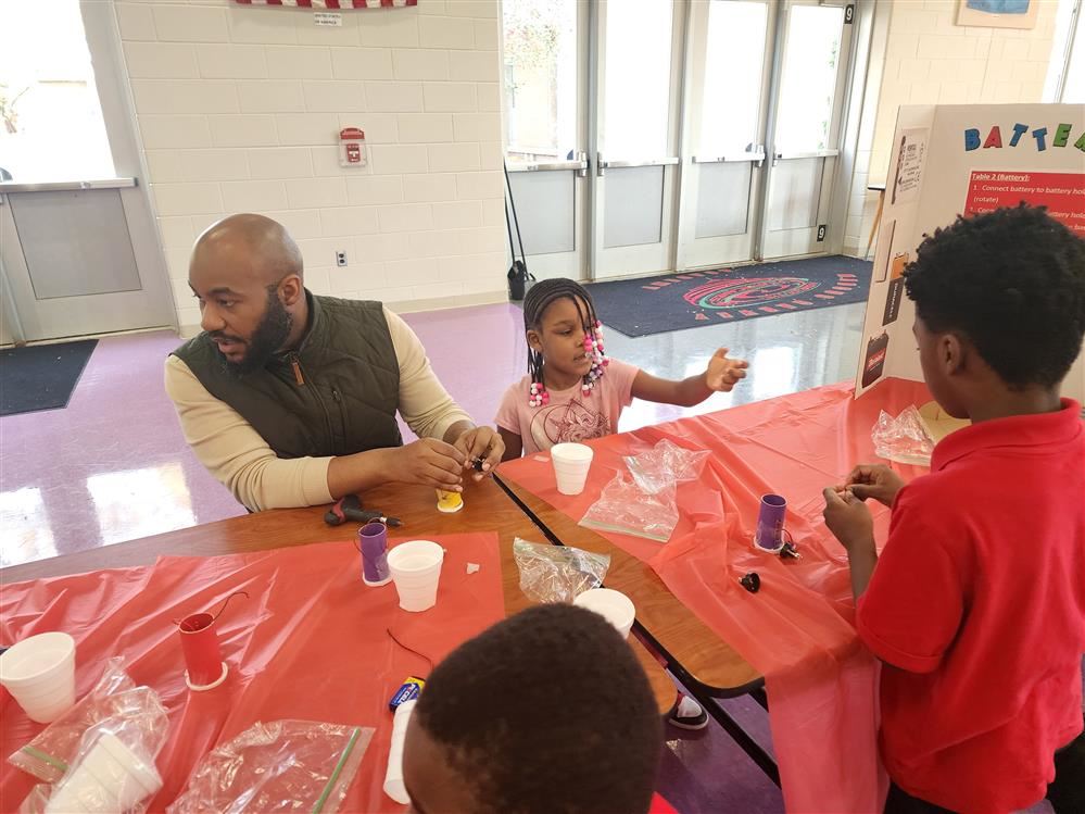 Male adult working with students