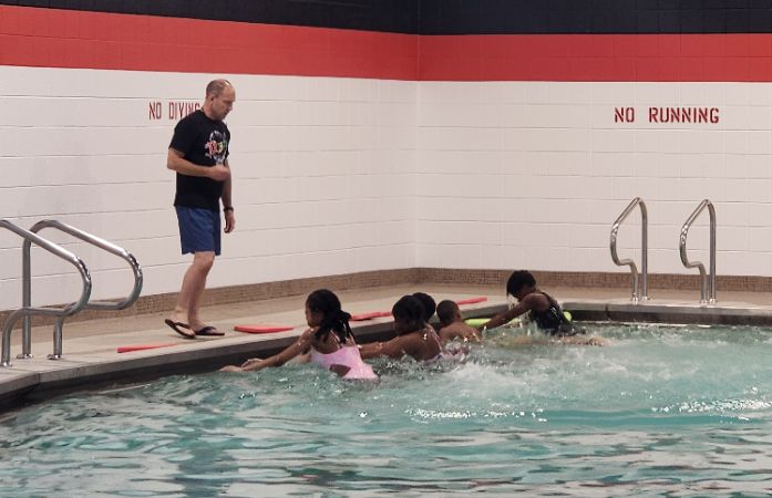  Students in pool with teacher watching