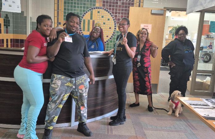  parents, staff, dog and principal standing on the school hallway 