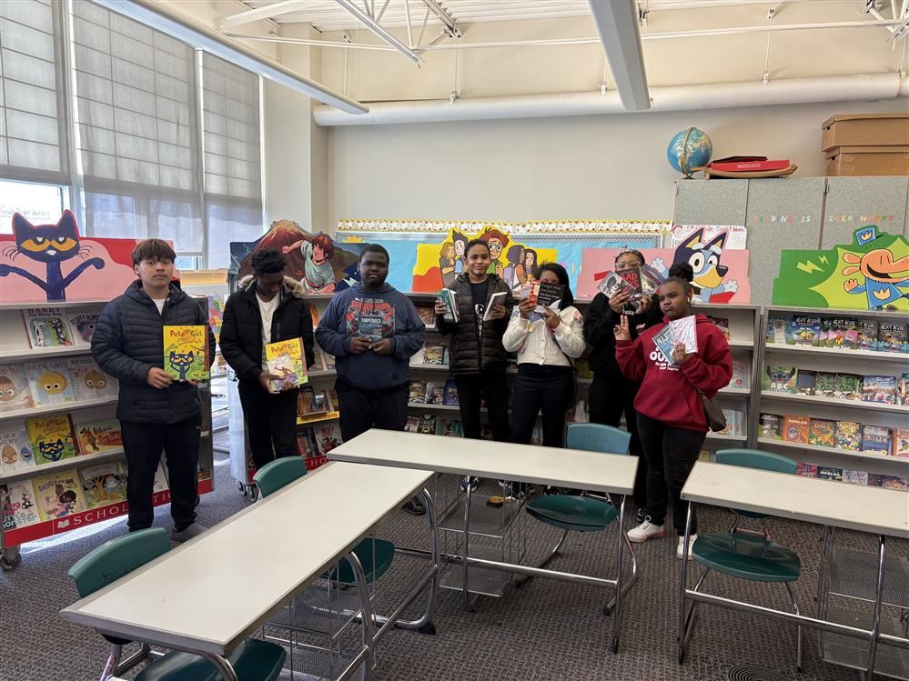  8 Students holding books in the classroom 