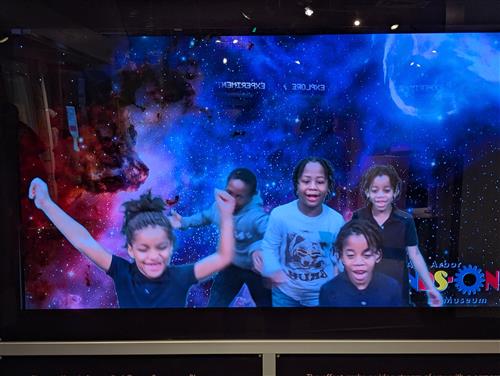 five students cheering with an excitement front of cosmic space backdrop!